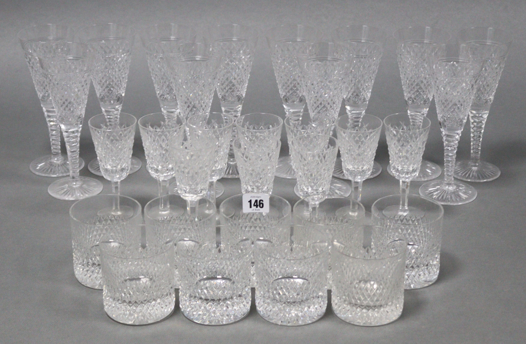 A set of twelve Stuart trumpet-shaped wine glasses, 7½” high; a set of ten Waterford glasses of