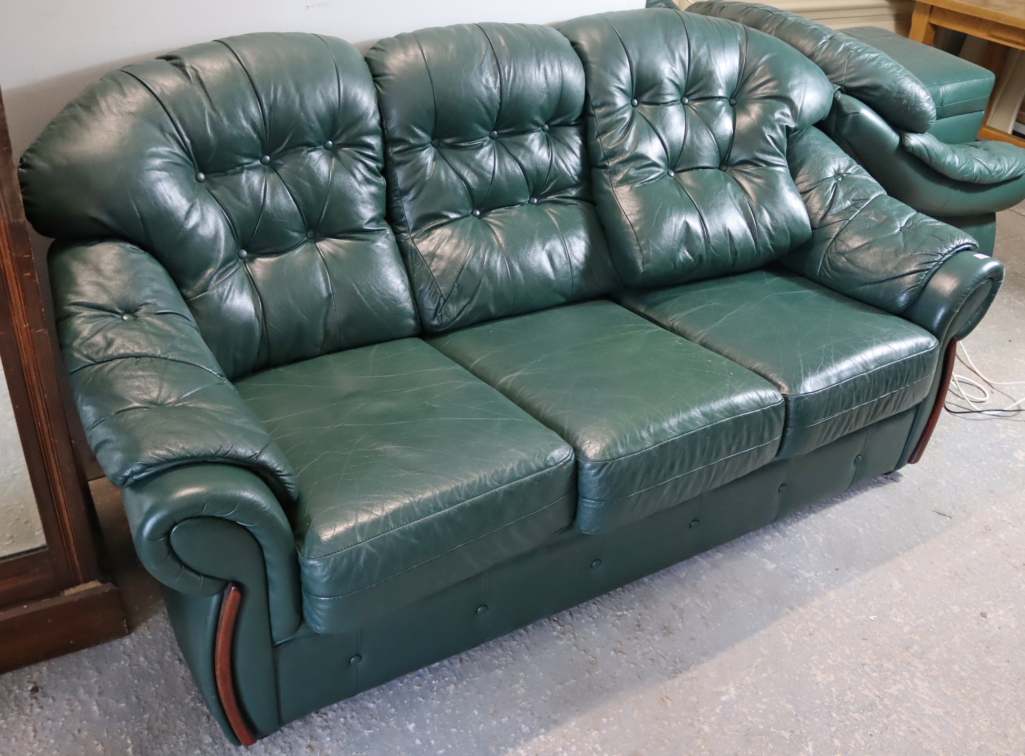 A green leather four-piece lounge suite comprising a three-seater settee, 77” long, a pair of