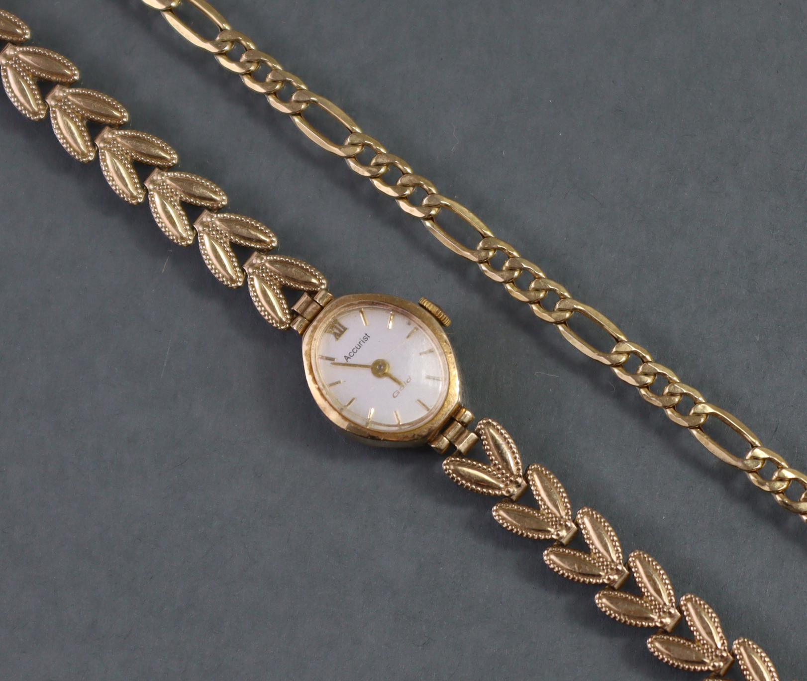 An Accurist 9ct. gold ladies’ wristwatch, the oval silvered dial with gold baton numerals & roman