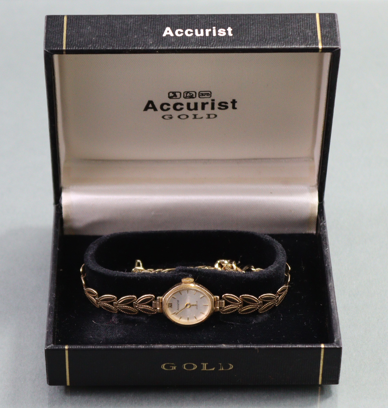 An Accurist 9ct. gold ladies’ wristwatch, the oval silvered dial with gold baton numerals & roman - Image 5 of 6