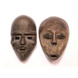 A Lega tribal mask with narrow eye slits & protruding mouth, 8½”; & another mask with decorative
