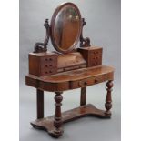 A Victorian mahogany “duchess” dressing table, with oval swing mirror to the stage back, fitted