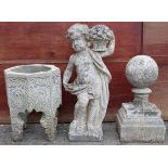 A reconstituted stone figure of a putto holding a basket of flowers, 31½” high; a ditto ball finial,