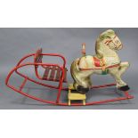 A mid-20th century lithographed tinplate child’s rocking horse, 23” high x 38” long.