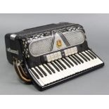 An Italian piano accordion in black & white polished case, & with fibre-covered carrying case.