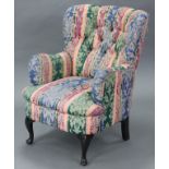 A Victorian-style armchair, with rounded buttoned-back & sprung seat upholstered multi-coloured