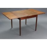 A teak draw-leaf dining table on four round tapered legs, 32¾” x 57¾” (open).