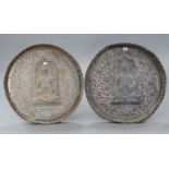 A pair of eastern copper circular wall plaques, each with raised deity design to centre & with all-