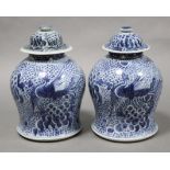 A pair of 19th century Chinese blue & white porcelain baluster vases & covers painted with phoenix &