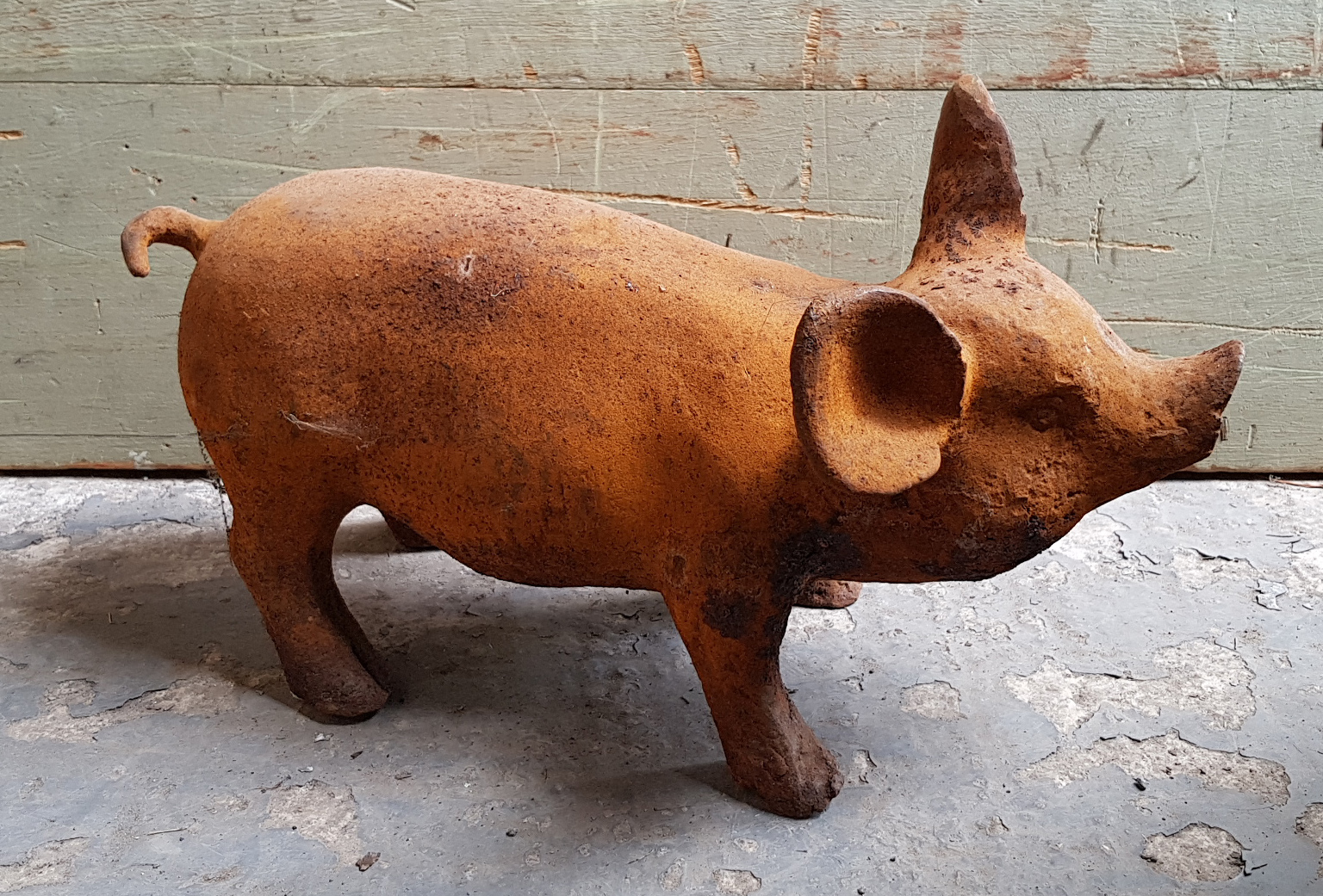 A modern cast-iron garden ornament in the form of a standing pig, 14½” long.