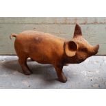 A modern cast-iron garden ornament in the form of a standing pig, 14½” long.