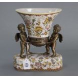 A Toussi Court flared oval vase supported by two gilt-brass cherubs, on rectangular ceramic base,