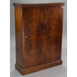 An Art Deco figured walnut cabinet, fitted three adjustable shelves enclosed by pair of panel doors,