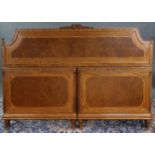 A late Victorian carved & inlaid walnut double bedstead, the shaped headboard & two-part footboard
