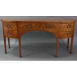An early 19th century inlaid-mahogany bow-front sideboard, fitted two frieze drawers flanked by a