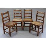 A set of four 19th century joined oak cottage dining chairs with shaped ladder backs & hard seats,