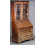 A George III figured mahogany bureau-bookcase, with moulded cornice above three adjustable