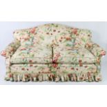 A Victorian-style two-seater sofa with shaped back & scroll arms, upholstered Colefax & Fowler “