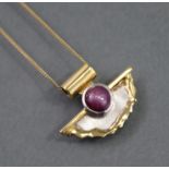 A contemporary 18ct. gold & ruby pendant by Nicholas Wylde of Bath, in yellow & white gold, of
