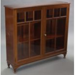 An early 20th century mahogany-finish bookcase, fitted four adjustable shelves enclosed by pair of