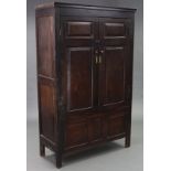 A late 17th century joined oak press cupboard, with moulded cornice above a pair of fielded panel