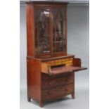 A regency mahogany secretaire bookcase, with ebonised string inlay, the moulded cornice above