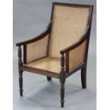 A Regency-style colonial rosewood frame bergere armchair, the reeded back, downswept arms, & square