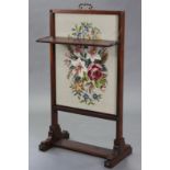An early Victorian mahogany frame firescreen with removable needlework panel to the centre, fitted