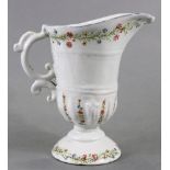 An 18th century French faience jug of silver-form helmet shape, with blue rim & floral decoration on