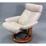 An Ekorness “Stressless” reclining swivel armchair, upholstered cream leather.