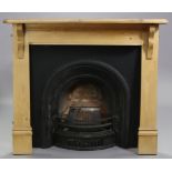 A cast-iron fireplace in the late Victorian style, with foliate borders to the central arch, the