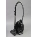 A Miele “Complete C3 Pure Power Powerline” vacuum cleaner, black, in original box.