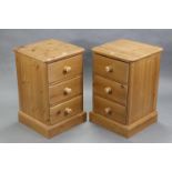 A pair of pine three-drawer bedside chests with turned wooden handles & on plinth bases, 16” wide