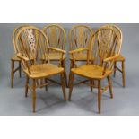 A set of six solid beech Windsor wheel-back dining chairs including a pair of elbow chairs, with