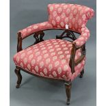 A Victorian tub-shaped low elbow chair with padded seat, back & arms & on short cabriole legs with