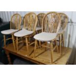 A set of six beech Windsor-style wheel-back dining chairs, with hard seats, ring turned legs with “