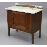 A mid-20th century oak marble-top washstand, fitted central cupboard enclosed by panel door on