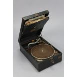 An H. M. V. portable record player in black fibre covered case, with a small quantity of 78 r. p. m.