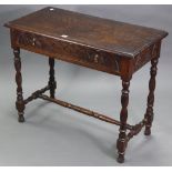 A carved oak side table, fitted full-length frieze drawer with brass drop handles, on turned
