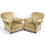 A pair of early 20th century armchairs, upholstered old gold stamped velour, & on turned feet.