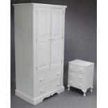 A similar white painted wardrobe, enclosed by pair of fielded panel doors above two long drawers, on