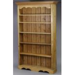 A pine open bookcase with moulded cornice, fitted one adjustable shelf, on plinth base, 52½” wide