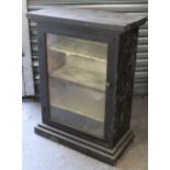 An early 20th century ebonised painted pine small upright display cabinet, fitted three shelves