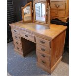 A late Victorian pine kneehole desk with plain rectangular top, fitted with an arrangement of nine
