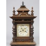 A Victorian mantel clock with Roman numerals to the square painted dial, in walnut case with moulded