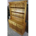 A modern pine dresser, fitted three shelves to the top above three frieze drawers with brass swan-