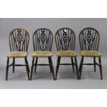 A set of four oak wheel-back dining chairs with padded seats.