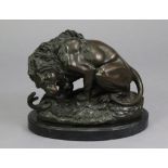 A bronze model of ‘the Lion and the Serpent’ after Barye, on oval rocky base with black marble