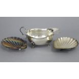 A silver oval sauce boat with cut-card rim, scroll handle, & on three pad feet, 5¾” long, Chester