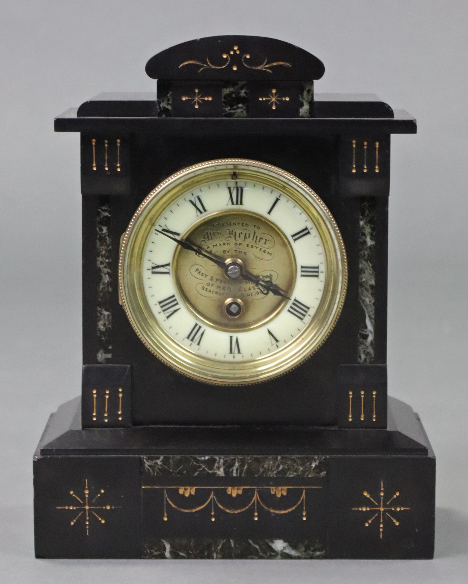 A Victorian mantel clock in black slate case with gilt decoration, the two-part dial with cream